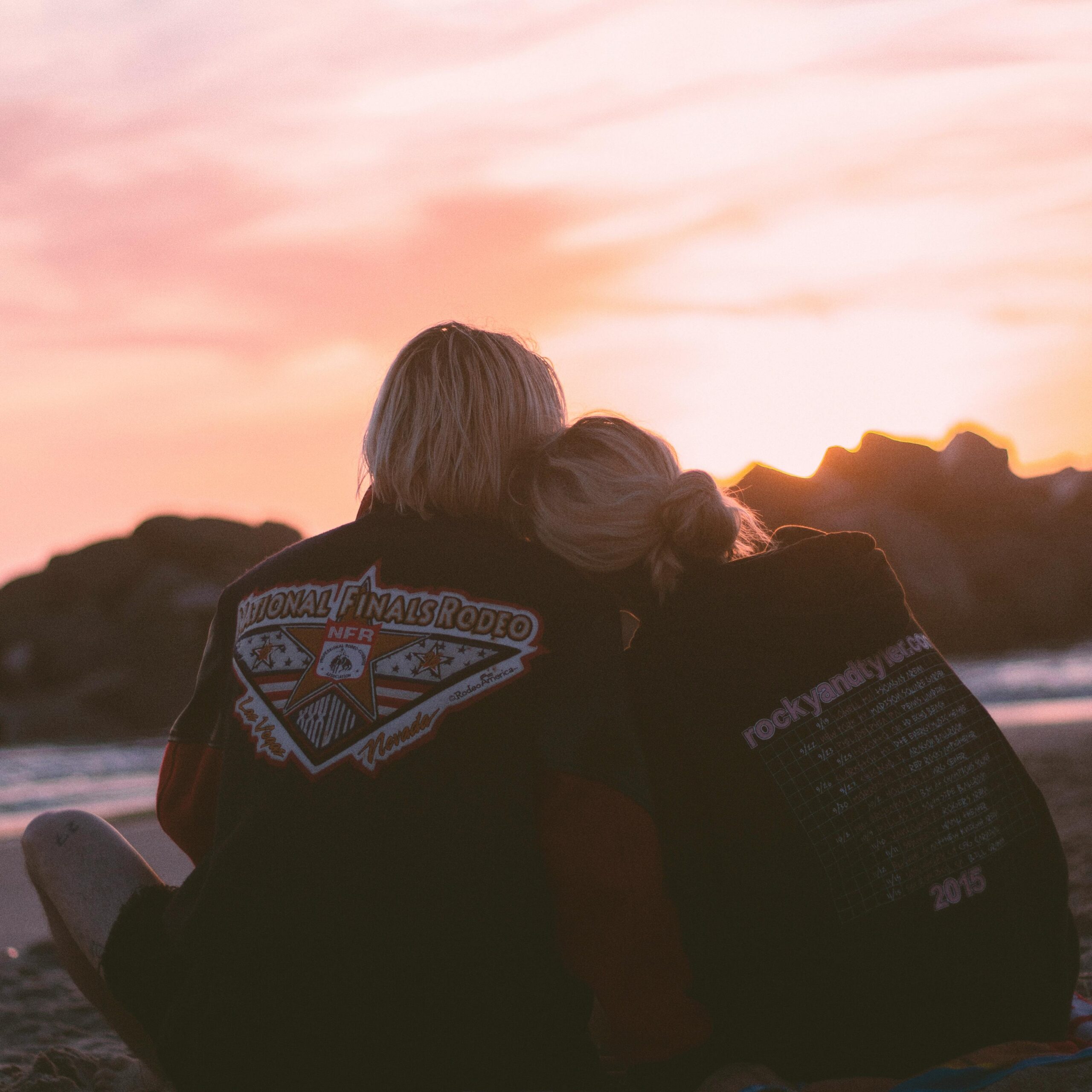 A couple embraces on the beach during a romantic sunset, symbolizing love and togetherness.